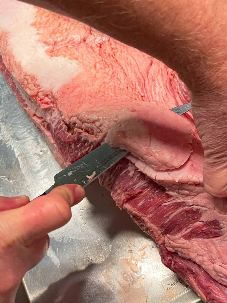Trimming fat from a brisket.