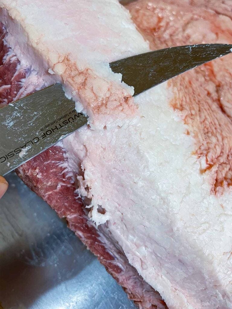 Trimming fat from a brisket.