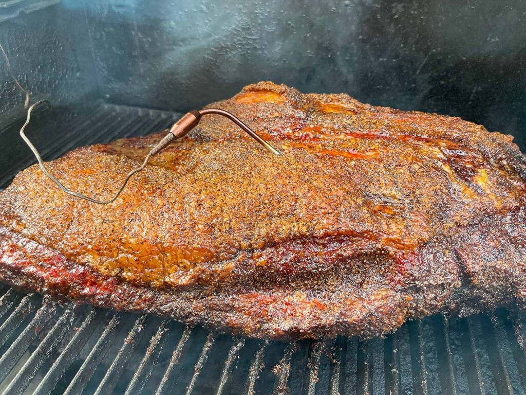 A brisket smoking in a smoker.