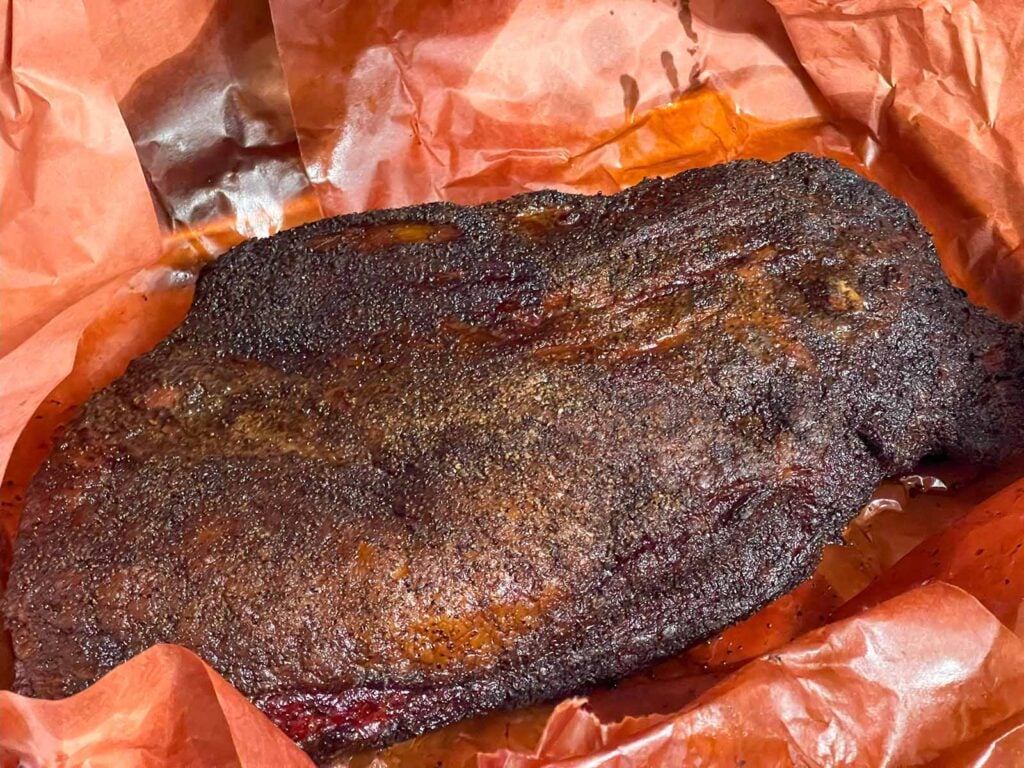 A smoked brisket with the butcher paper unwrapped.