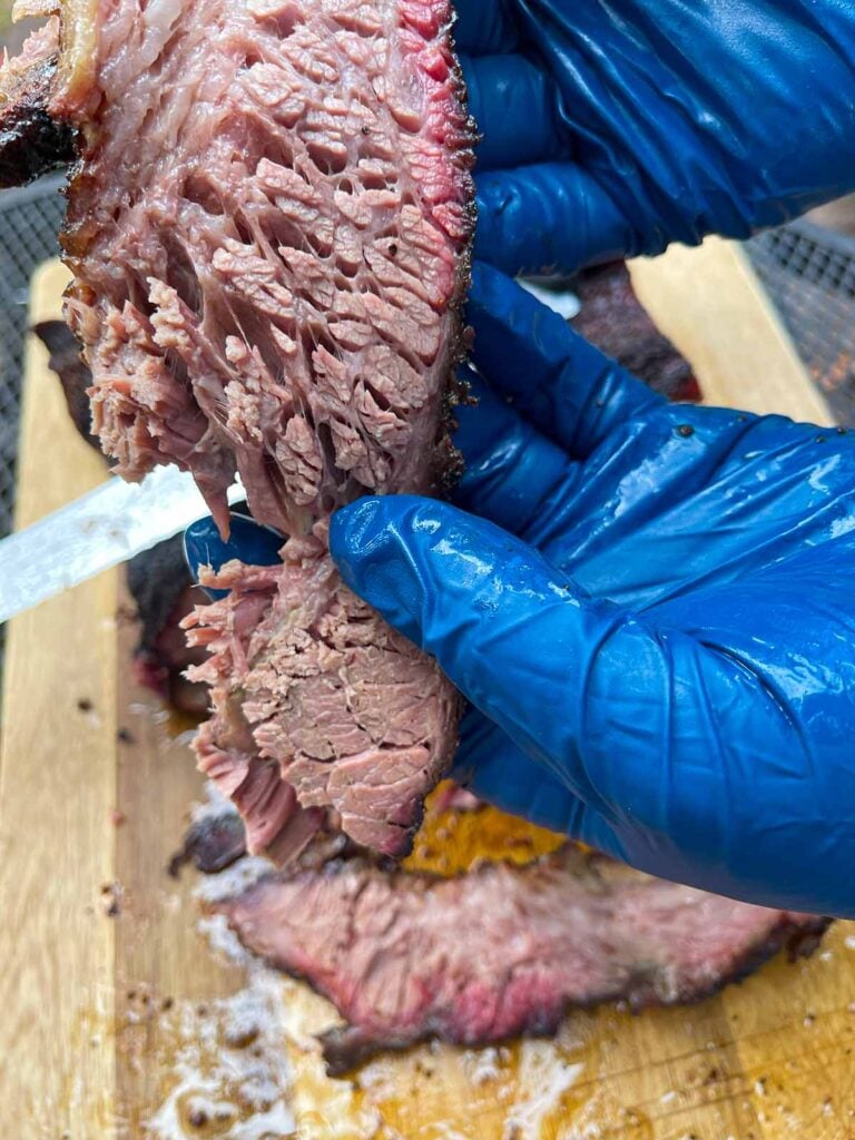 Showing how tender the brisket it by pulling it.