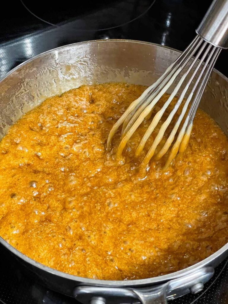 Toffee mixture boiling in a metal saucepan.