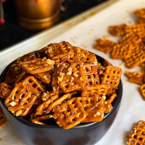 Butter toffee pretzels in a dark bowl on the baking sheet.