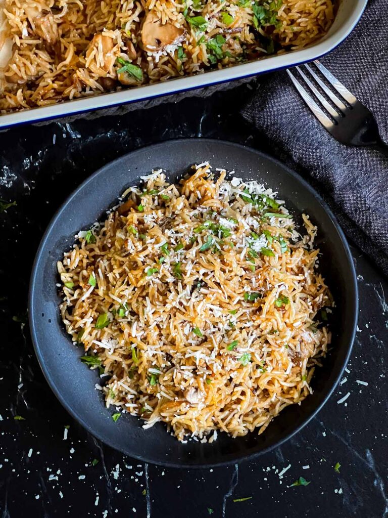 Basmati rice risotto (stick of butter rice) in a dark bowl.