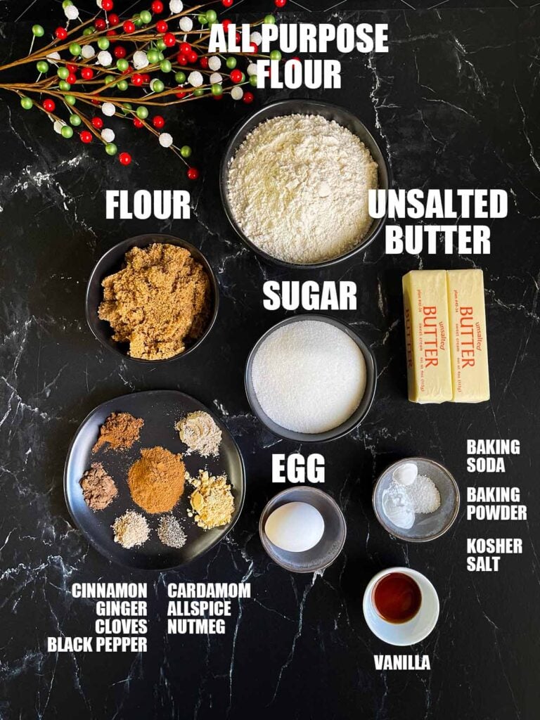 Ingredients for chai sugar cookies on a dark surface.