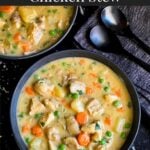 Chicken stew in a dark bowl.