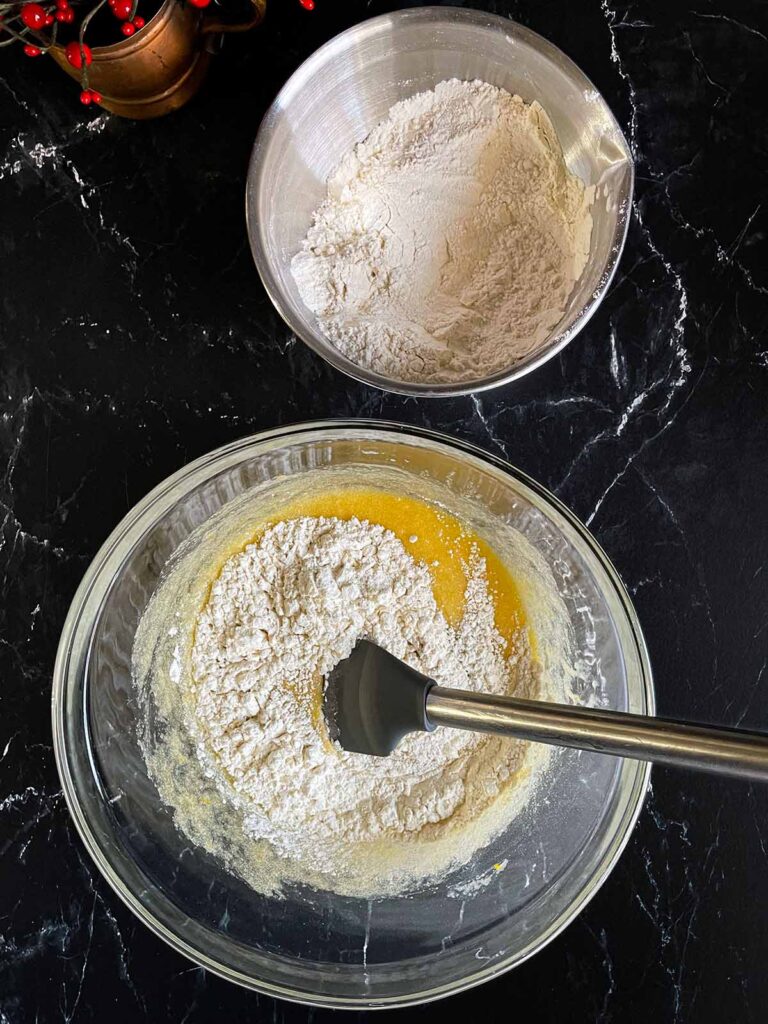 Dry ingredients being added to the wet ingredients for cranberry pistachio biscotti.