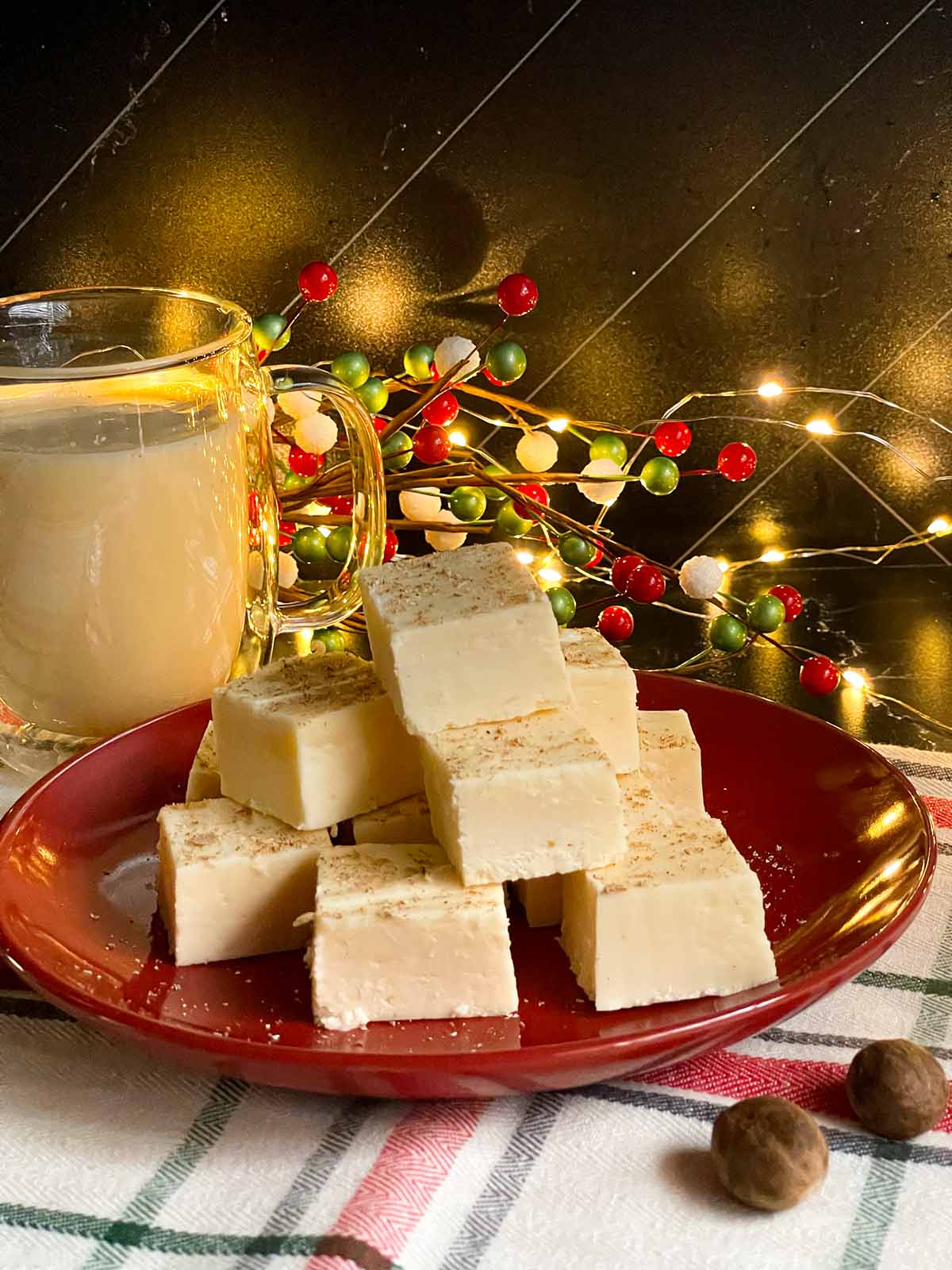 Eggnog fudge garnished with ground nutmeg and stacked on a plate.