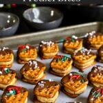 Chocolate covered peanut butter pretzel bites on a parchment paper lined baking sheet.