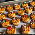 Chocolate covered peanut butter pretzel bites on a parchment paper lined baking sheet.