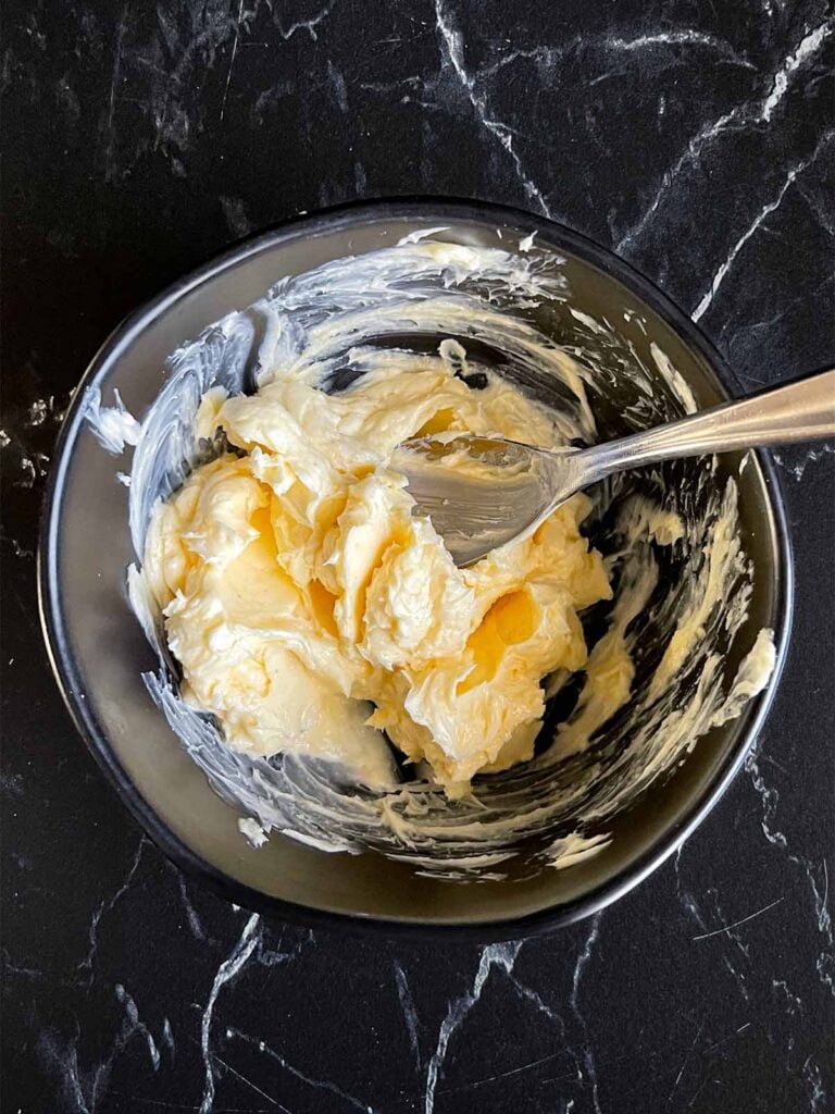A garlic butter mixture in a dark bowl.