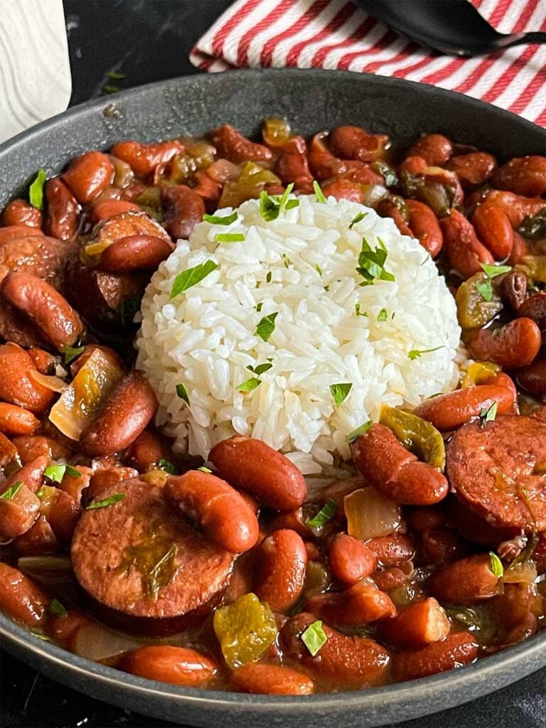 Slow cooker red beans and rice in a dark bowl on a dark surface.