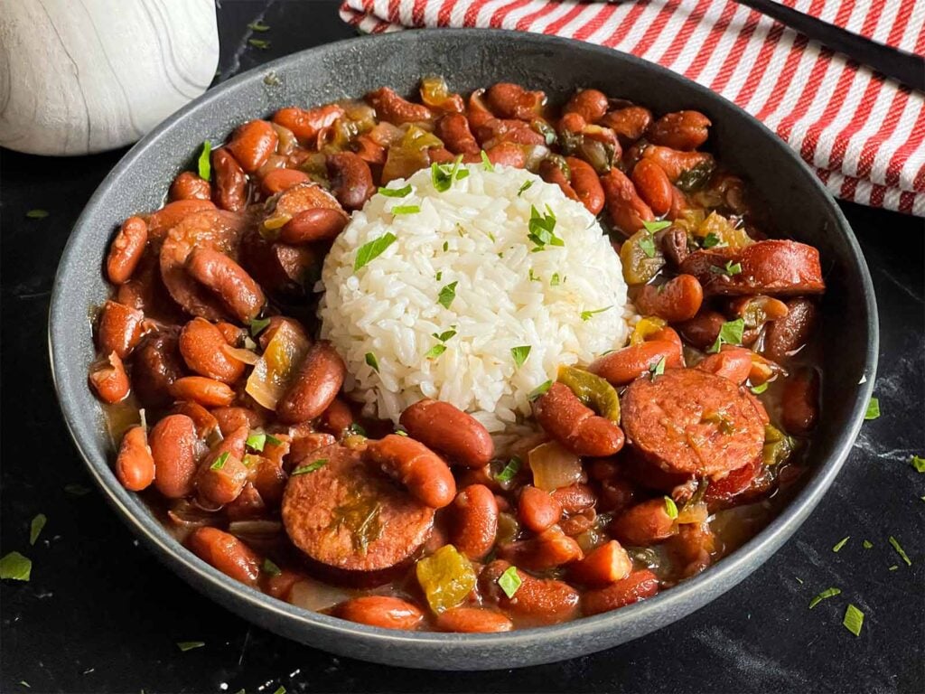 Slow cooker red beans and rice in a dark bowl on a dark surface.