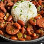 Slow cooker red beans and rice in a dark bowl on a dark surface.