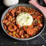 Slow cooker red beans and rice in a dark bowl on a dark surface.