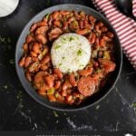 Slow cooker red beans and rice in a dark bowl on a dark surface.