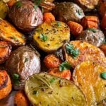 Roasted potatoes and carrots on a baking sheet.