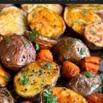 Roasted potatoes and carrots on a baking sheet.