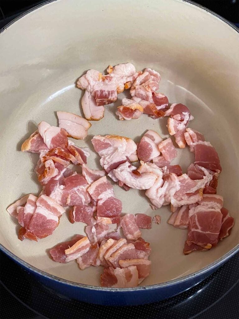 Uncooked chopped bacon in a dutch oven.