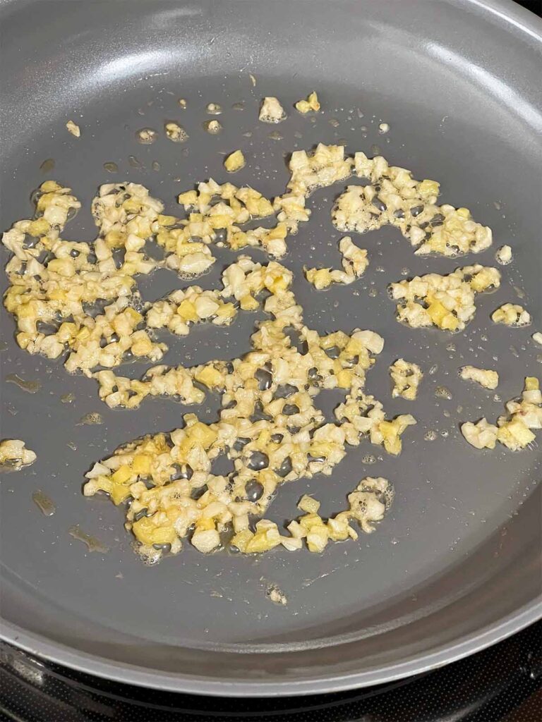 ginger and garlic sauteing in a skillet.