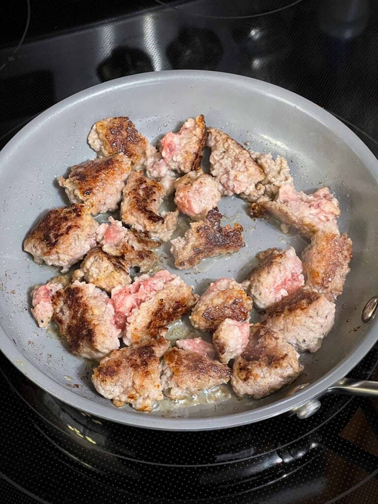 Browned sausage in a small skillet.