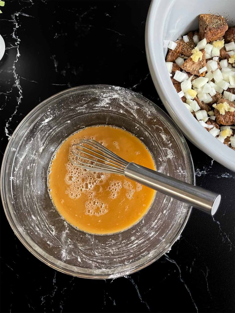 Beef broth and Worcestershire sauce whisked together with the remaining flour in a glass bowl.