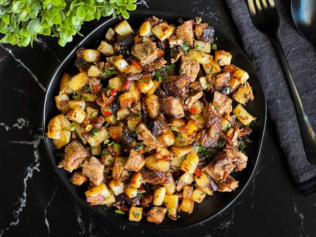 Smoked brisket hash on a dark plate.