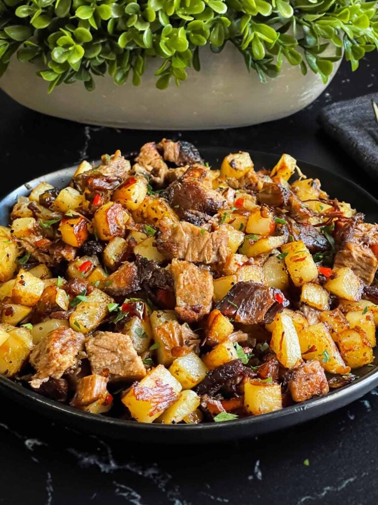 Smoked brisket hash on a dark plate.