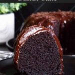 A slice of chocolate bundt cake on a dark plate.