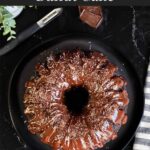 A chocolate bundt cake on a dark plate.