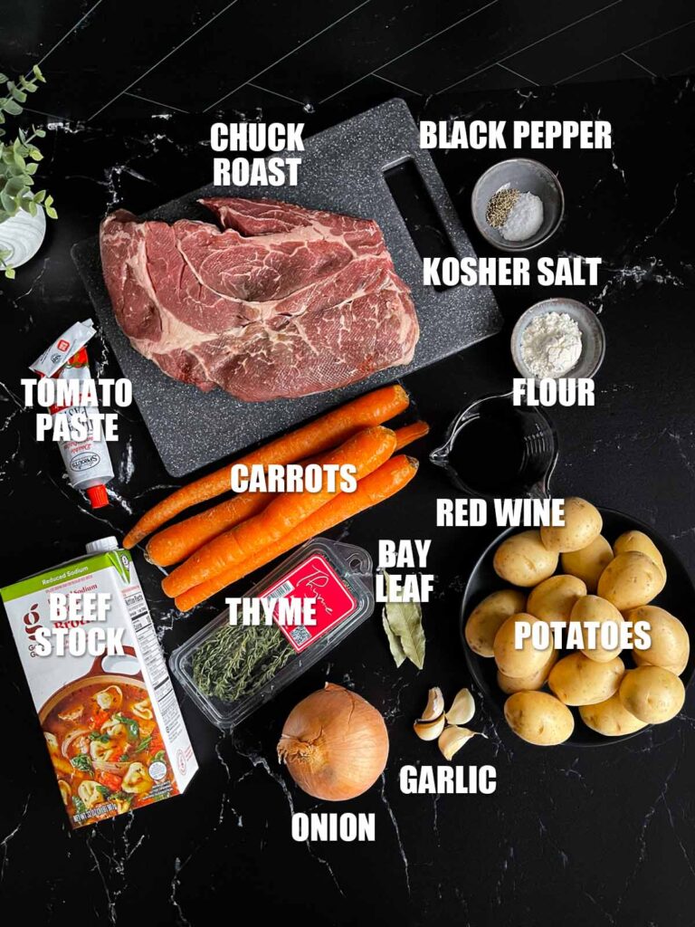 Classic pot roast recipe ingredients on a dark surface.