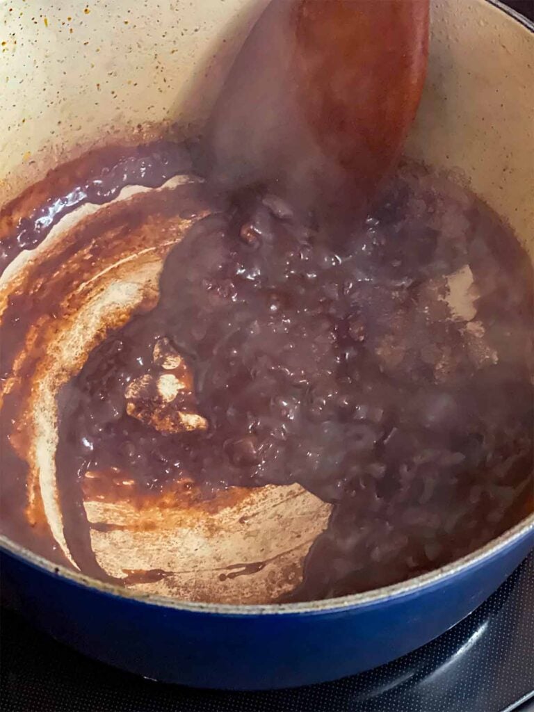 Red wine reducing in the dutch oven with the other ingredients for the pot roast recipe.