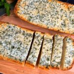 Garlic bread on a cutting board.