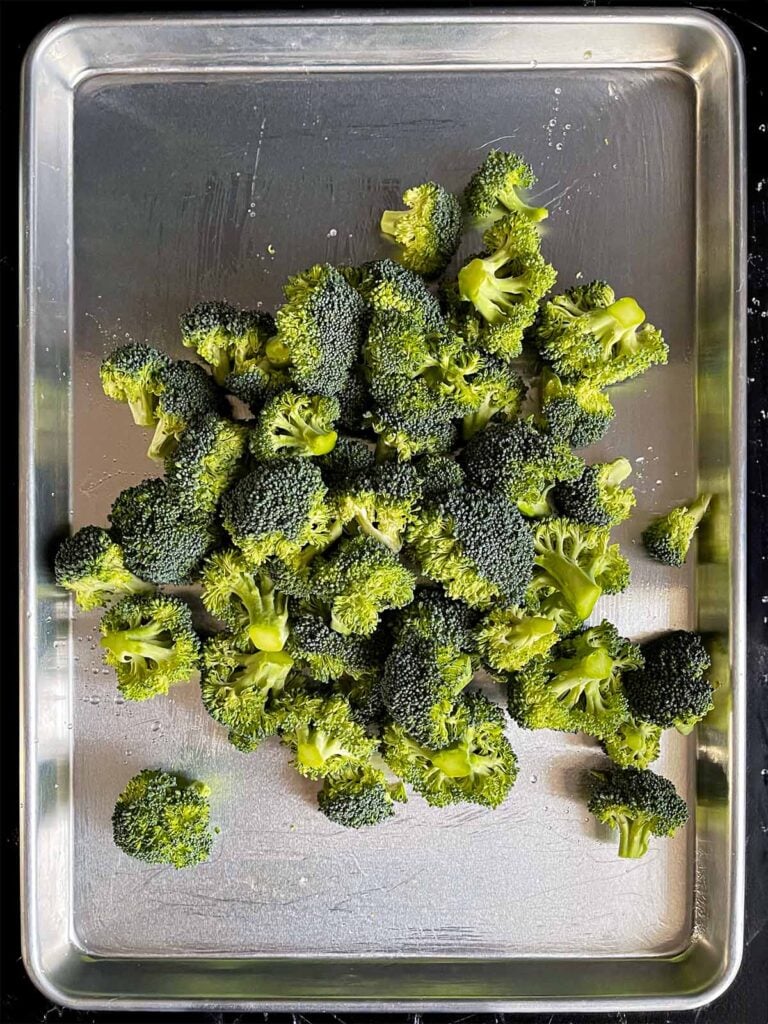 Broccoli florets on a baking sheet.