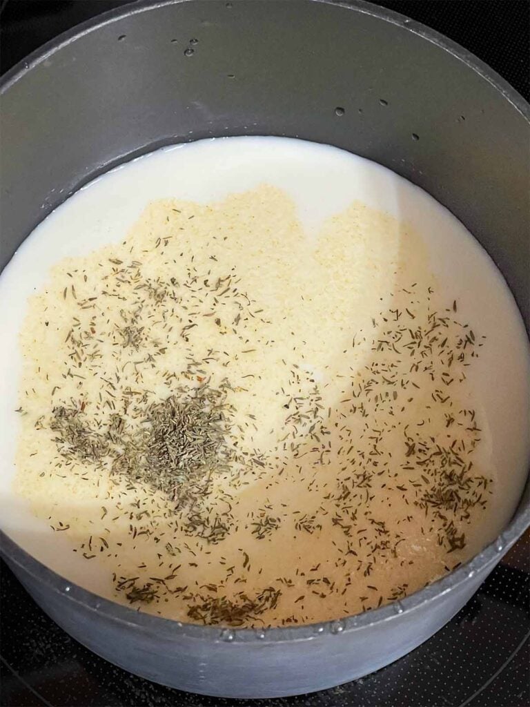 Milk with seasonings in a saucepan.