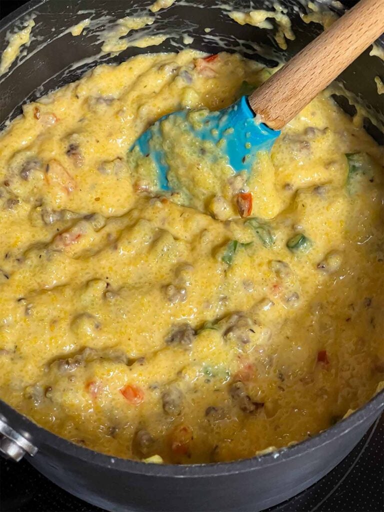 Grits with sausage and other herbs and spices in a saucepan.