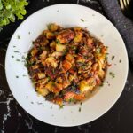 Smoked pulled pork hash garnished with parsley in a white bowl.