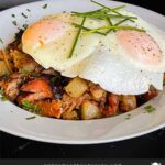 Smoked pulled pork hash garnished with parsley in a white bowl.