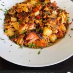 Smoked pulled pork hash garnished with parsley in a white bowl.