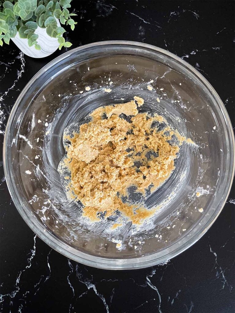 Sugars and butter creamed together in a glass mixing bowl for almond joy cookies recipe.