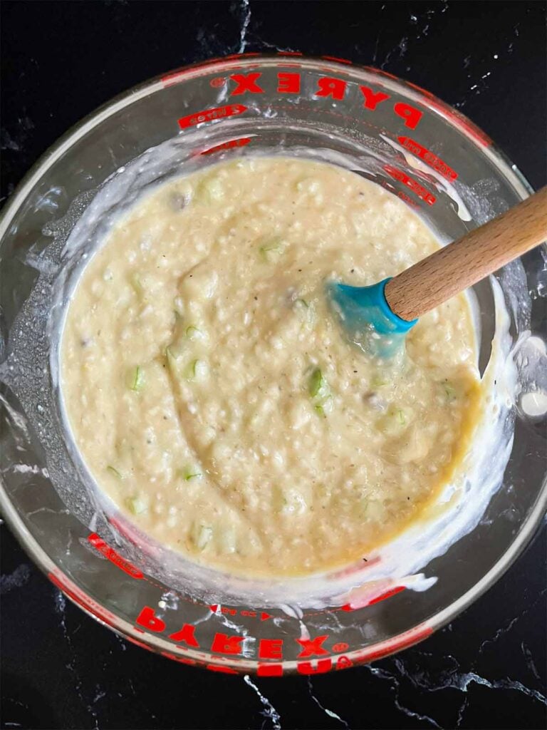Soup, celery, and rice mixture in a large glass measuring cup.