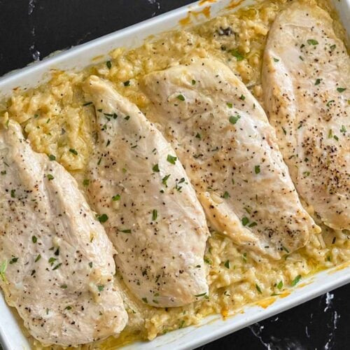 Chicken and rice casserole in a light baking dish on a dark surface.