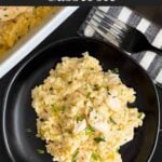 Chicken and rice casserole garnished with chopped parsley on a dark plate on a dark surface.