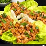 Chicken lettuce wraps on a dark plate.