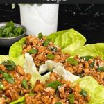 Chicken lettuce wraps on a dark plate.