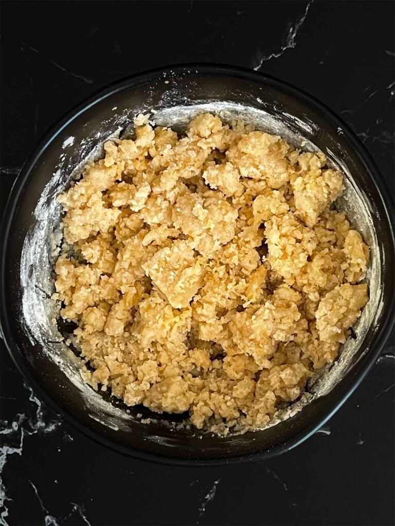 Lemon crumb cake crumble ingredients mixed in a dark bowl.