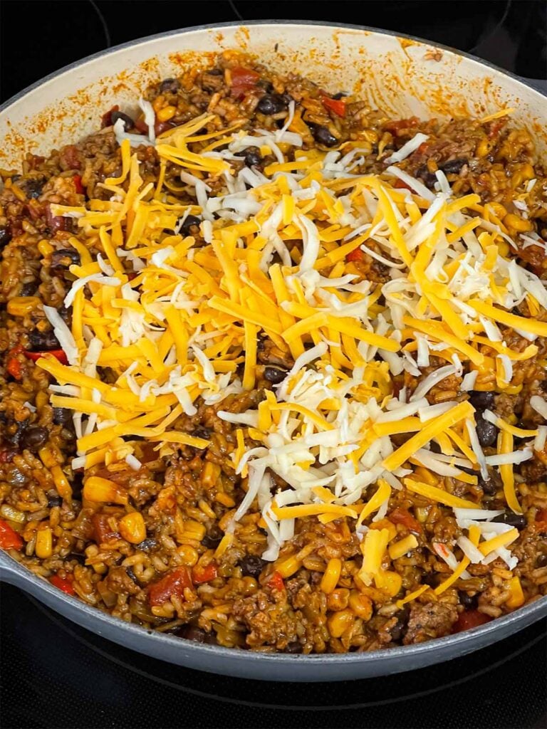 Adding cheese to the Mexican ground beef mixture.