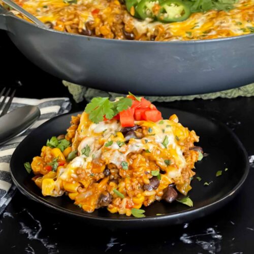 Mexican ground beef with rice with a serving on a dark plate.