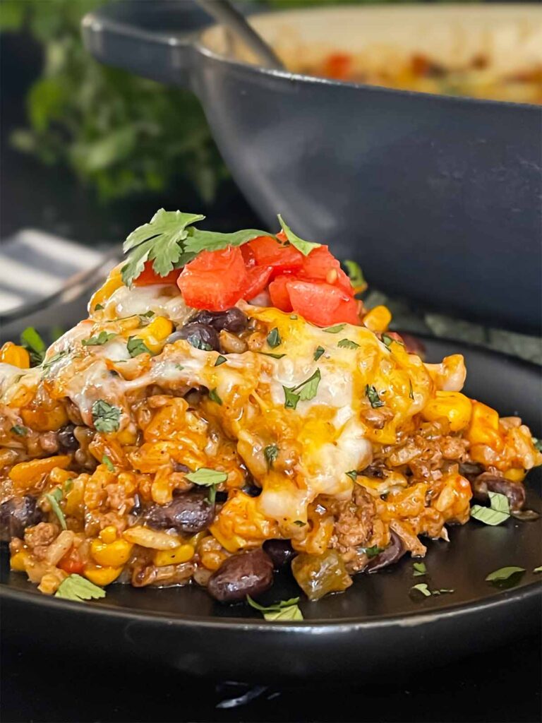 Mexican ground beef casserole with rice  on a dark plate.