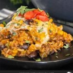 Mexican ground beef with rice with a serving on a dark plate.